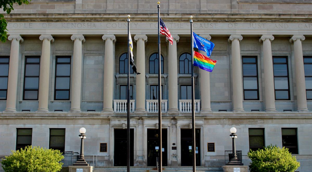 The Rainbow Pride flag flies in front of the Kenosha County Courthouse