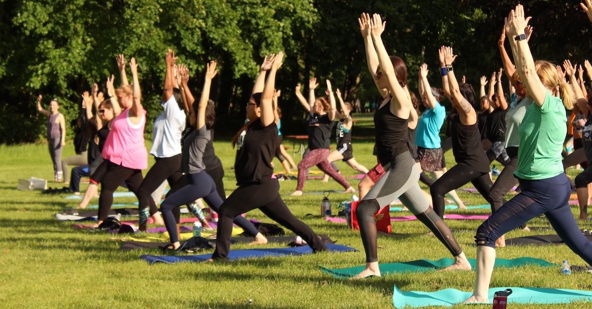 People participate in Yoga in the Park at Petrifying Springs Park