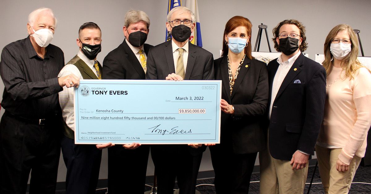 Kenosha County officials receive a large check from Gov. Evers