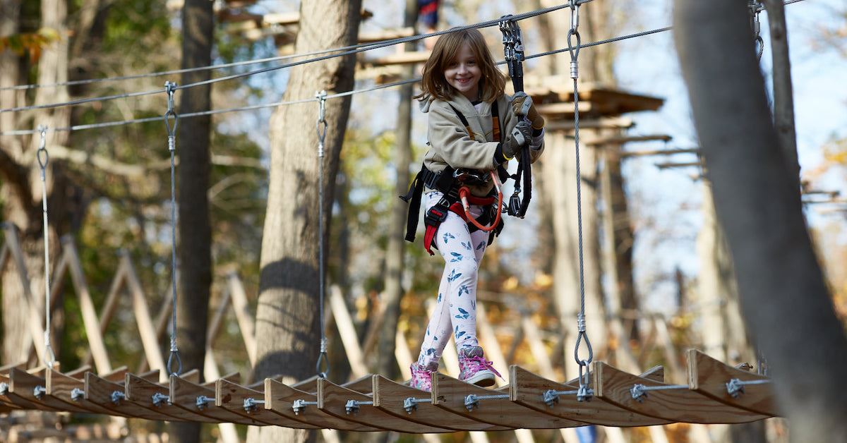 Photo of a girl climbing the ropes course at Boundless Adventures