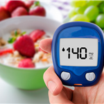 bowl of fruit with a blood sugar meter registering a number. 