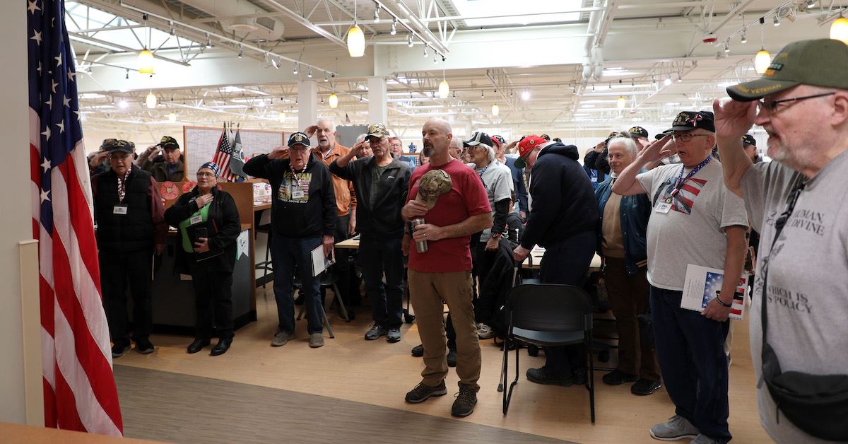 Photo of a large group of veterans singing the National Anthem at the Heroes Cafe
