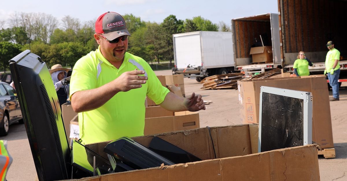 Photo of county worker disposing of electronics at a hazardous waste collection event