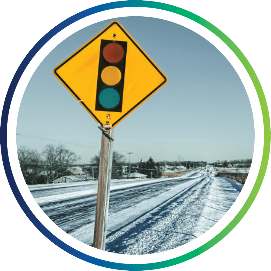 A stoplight sign on a snowy road